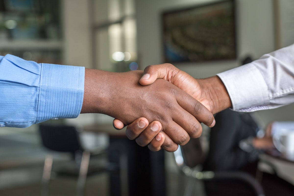 Apretón de manos entre dos representantes de organizaciones