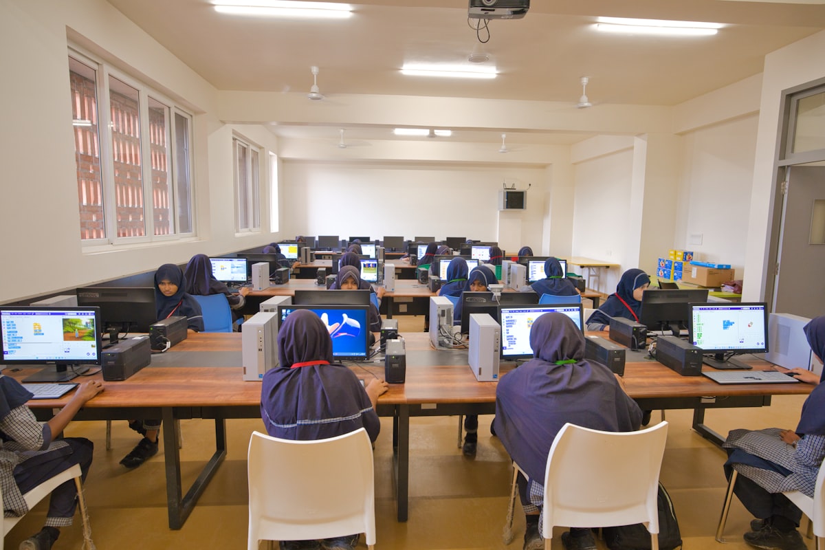 Estudiantes trabajando en computadoras dentro de un laboratorio de cómputo